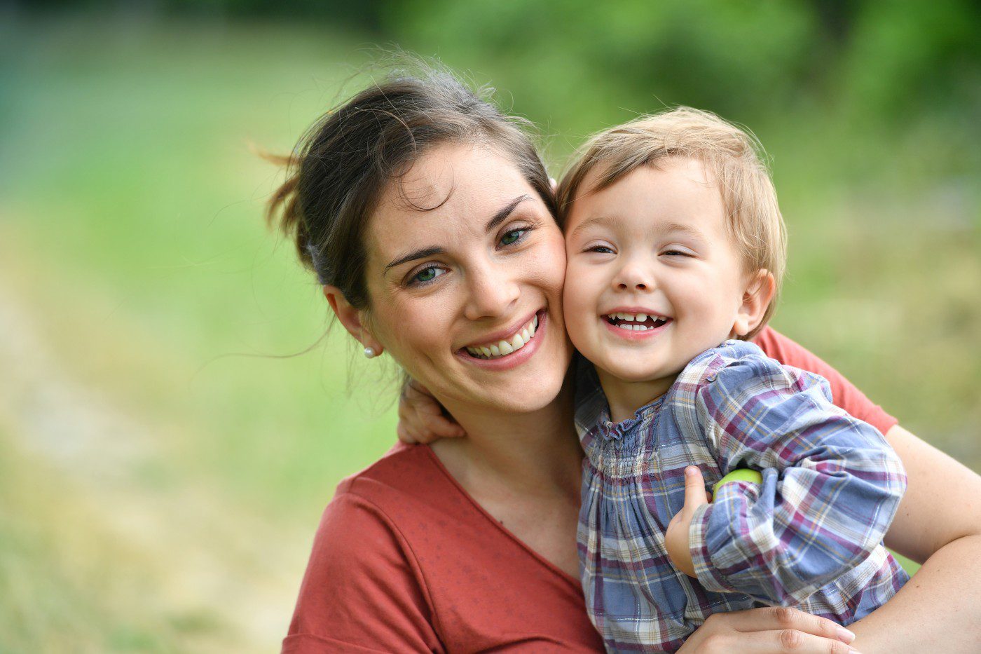 Smiling mother holding laughing toddler