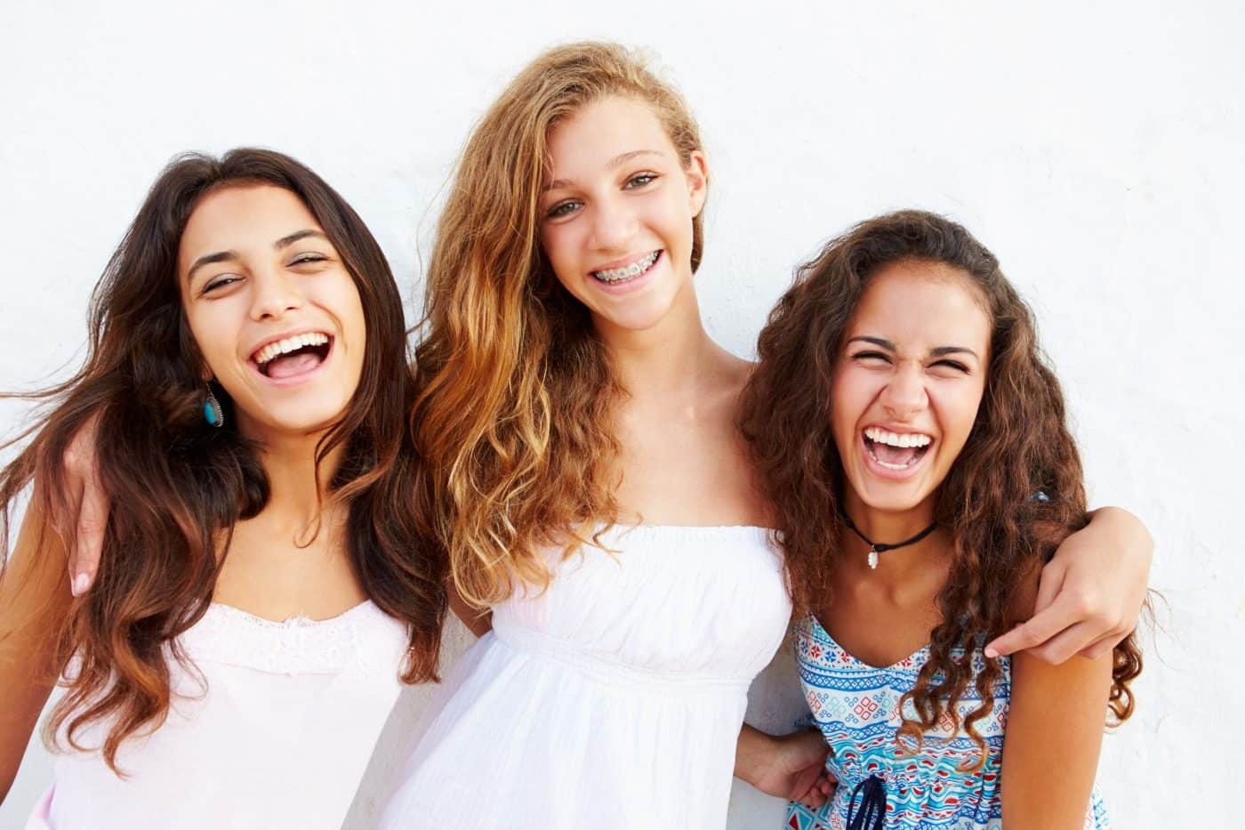 three teen girls smiling and laughing