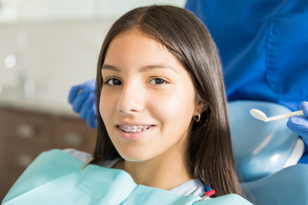 girl smiling in ortho chair Orthodontic Care: No Referral Necessary